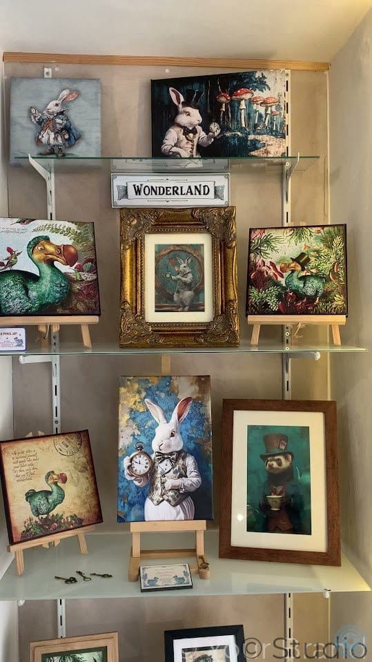 Shelf displaying various framed artworks with a 'Wonderland' sign above.