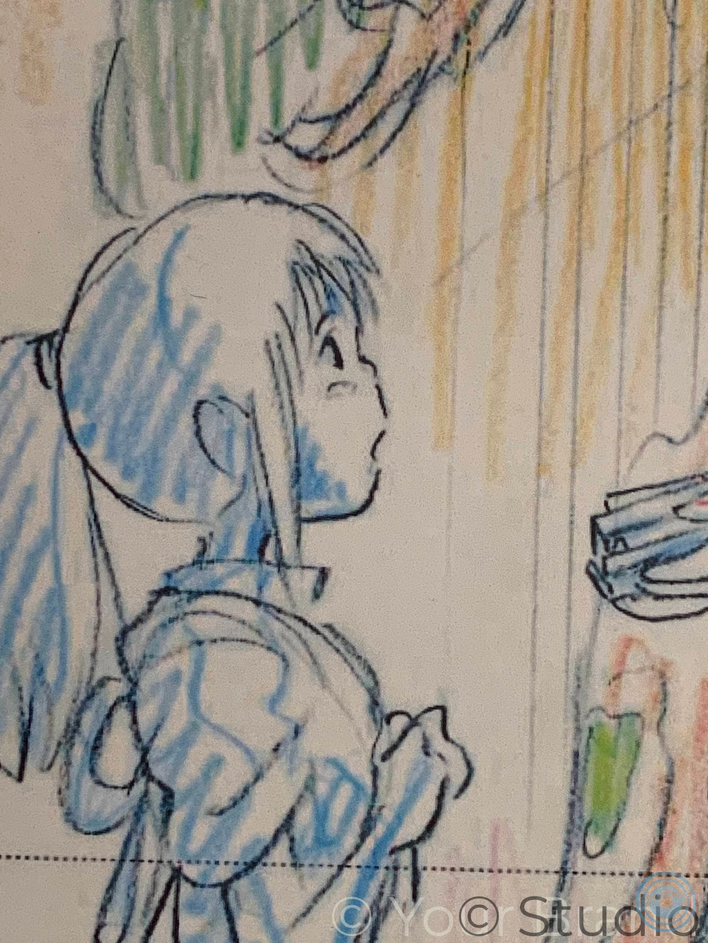 A close-up of a colored pencil sketch on paper, showing a side profile of a character with blue hair and a blue outfit, alongside yellow and green pencil strokes. Spirited Away print